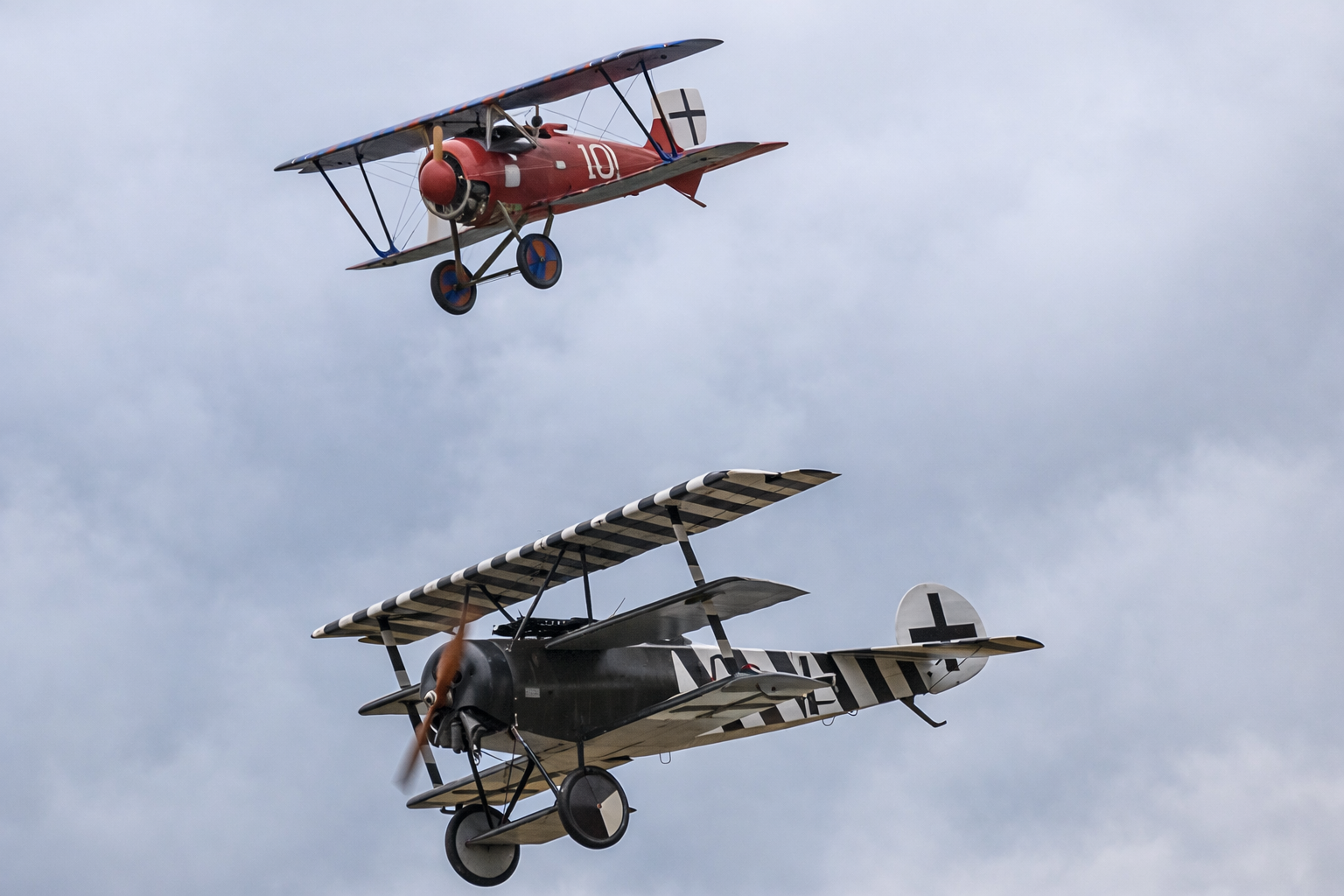 Two vintage biplanes flying in the sky with gray clouds background.  Technical Composites for aerospace.
