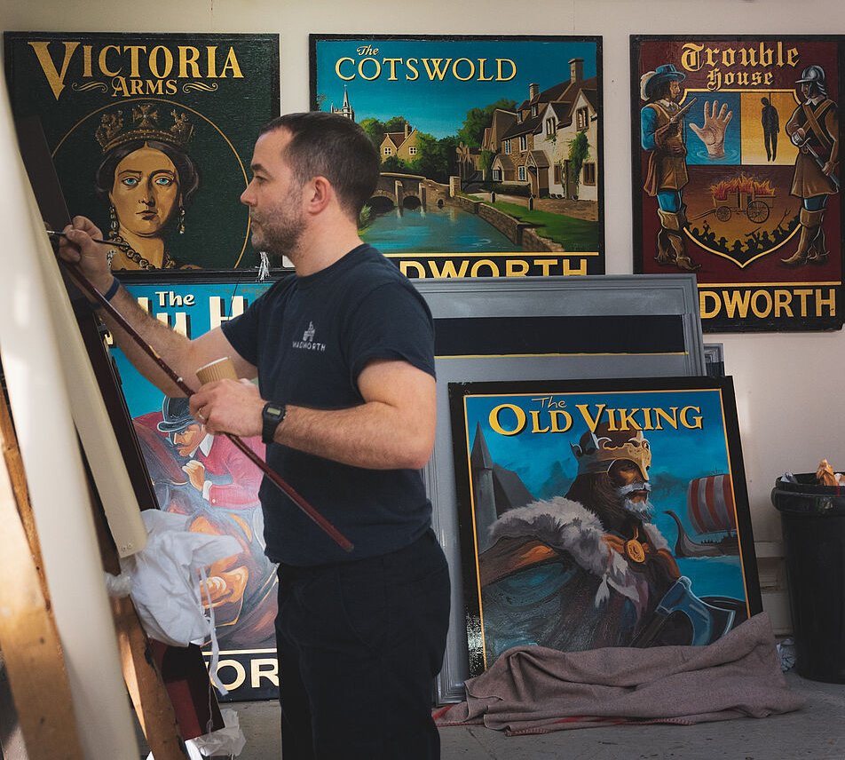 Man painting Wadsworth pub sign.  Creative and Custom fibreglass and composite solutions. 