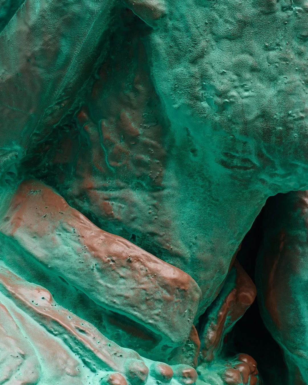 Close-up of a bronze statue showing textured and weathered surface detail.