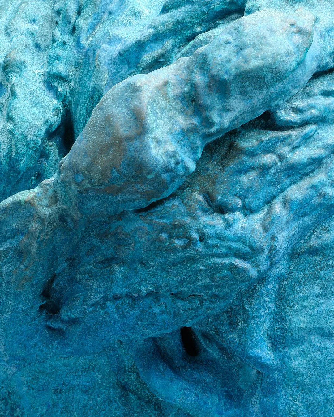Close-up view of a glacier with blue ice and textured surface.