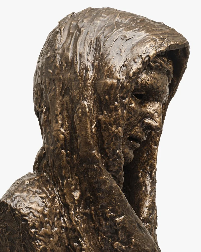 Bronze sculpture of a woman with a hood over her head, with detailed facial and hair features.