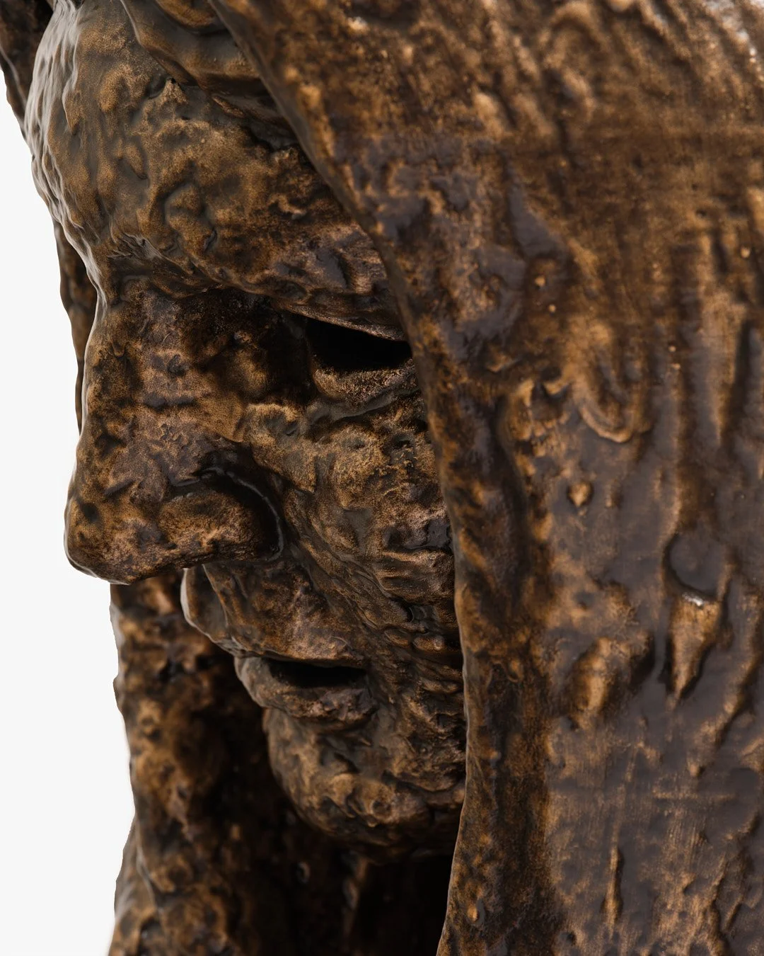 A close-up of a textured bronze sculpture of a human face in profile.