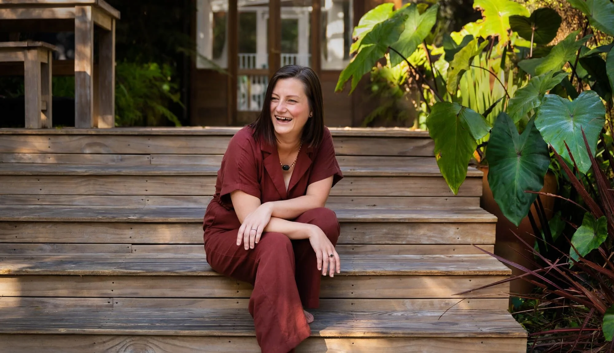 Meditation teacher sitting on outside steps, smiling