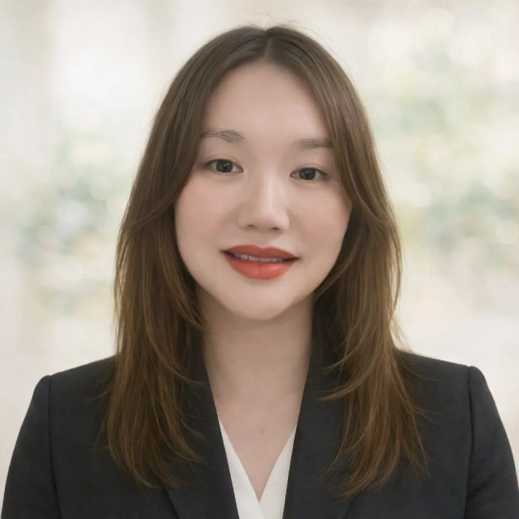 A woman with shoulder-length brown hair, wearing a black blazer and a white top, smiling at the camera.