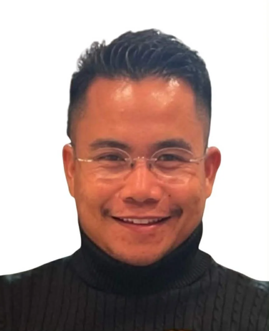 A smiling man wearing glasses and a black turtleneck sweater.