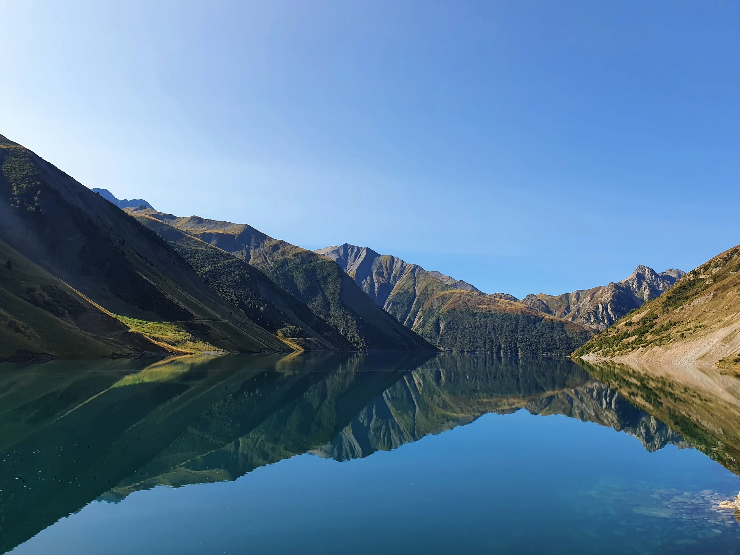 Montagnes verdoyantes et lac calme reflétant le paysage