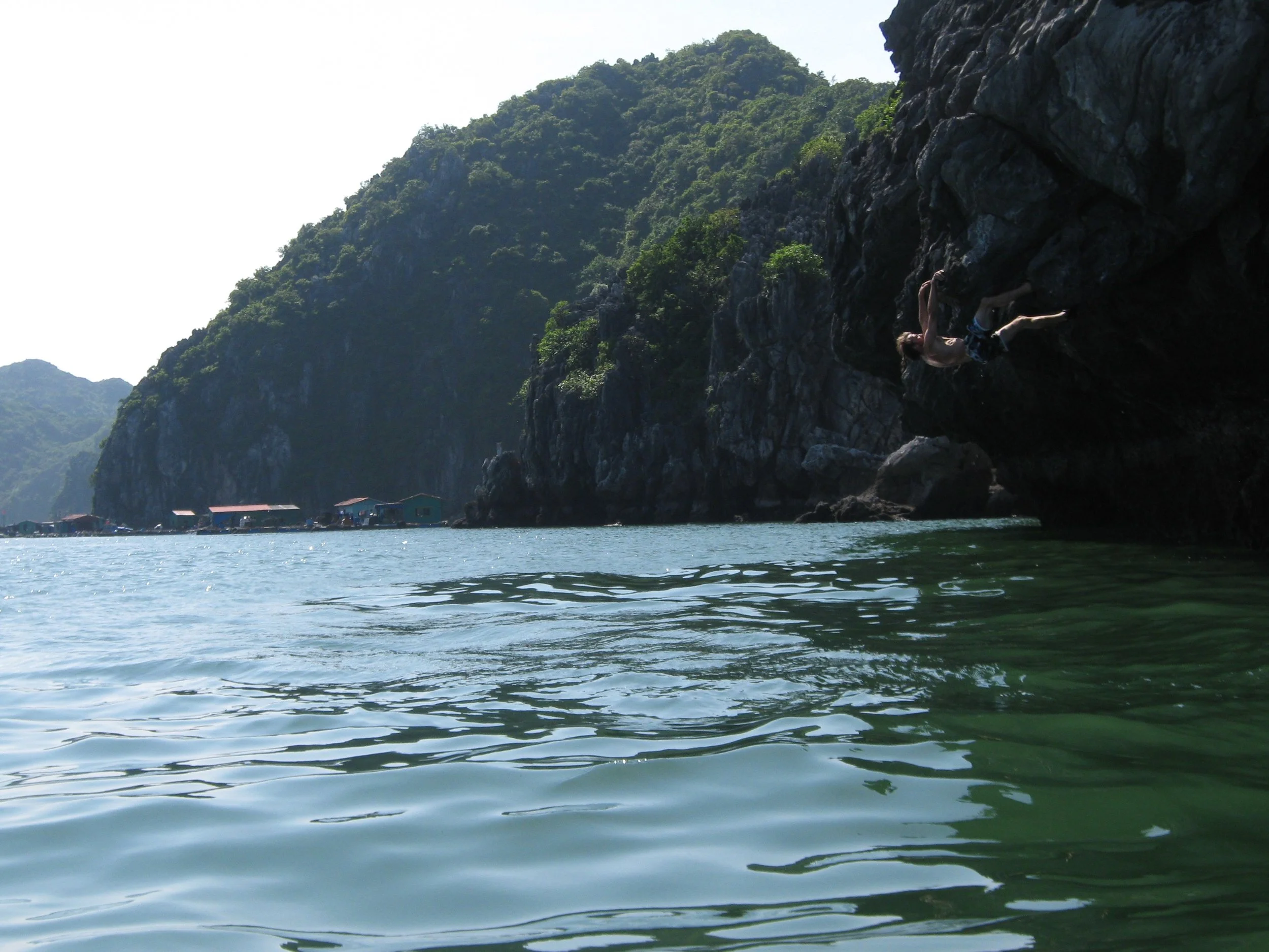 Moi en train d'escalader une falaise rocheuse au bord de l'eau. Vietnam