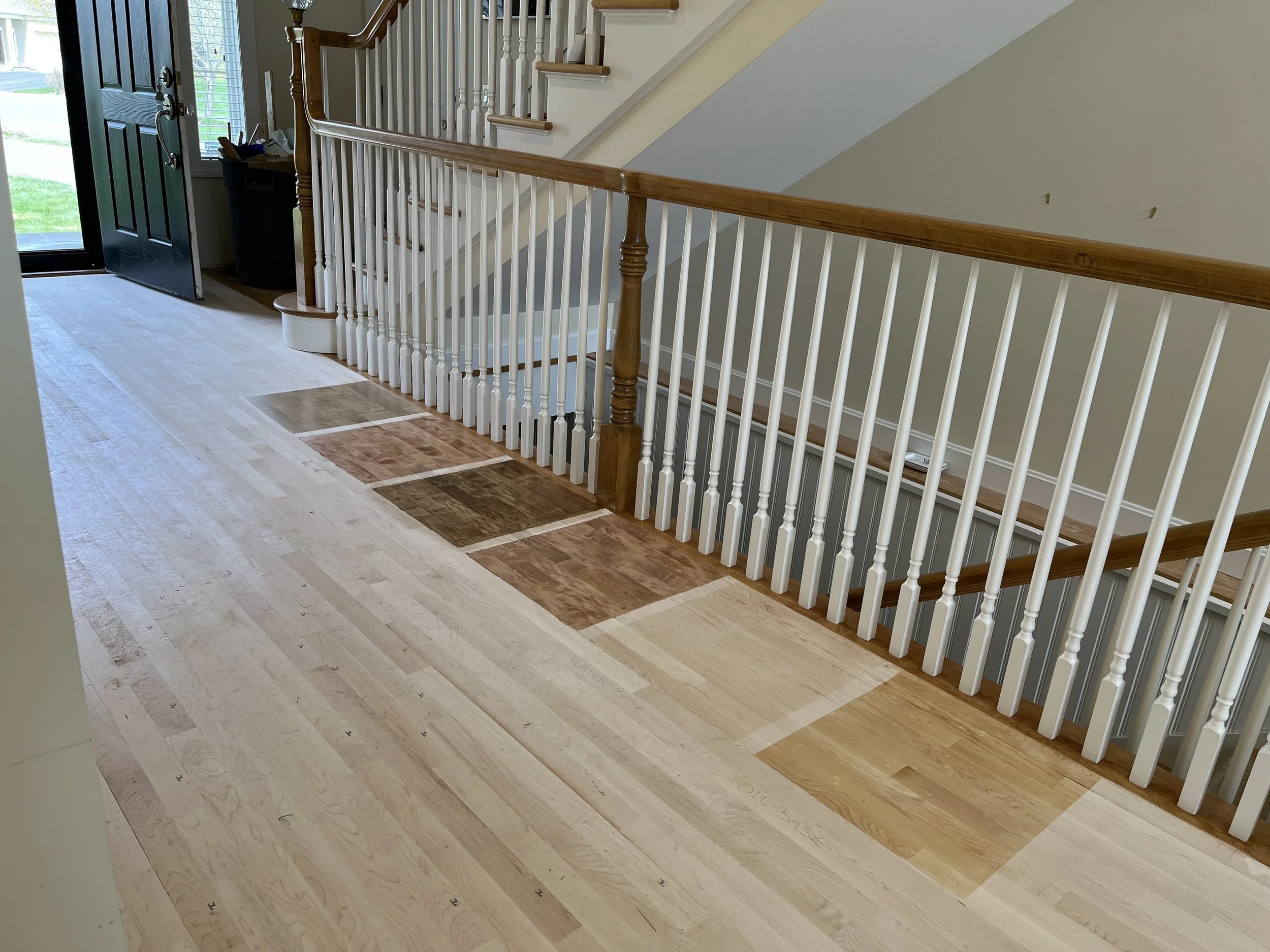 Stain color samples applied to a maple floor.