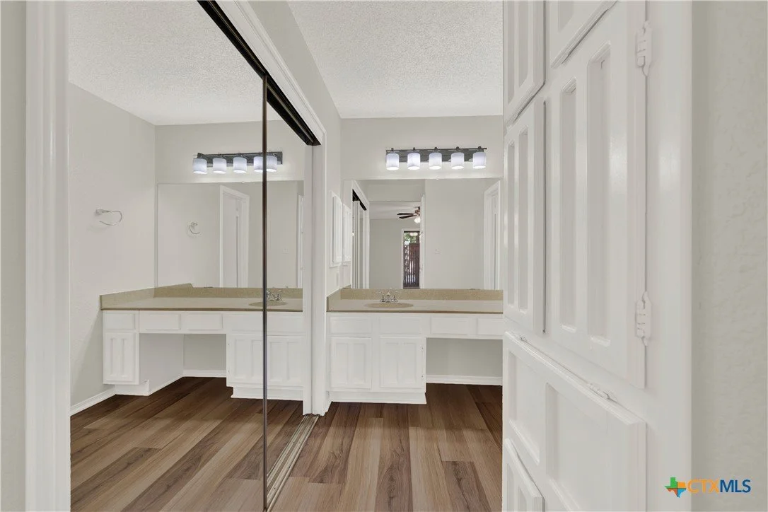 Bathroom vanity with mirror and wood flooring