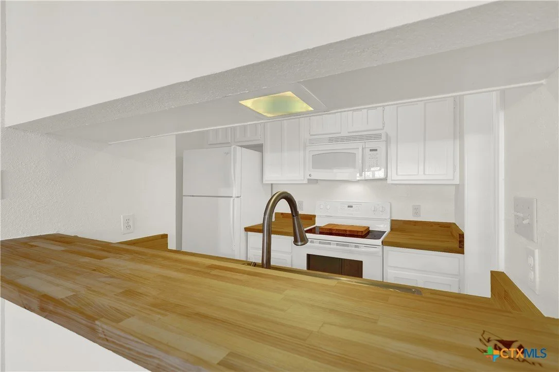 Kitchen with white appliances, wooden countertops, and a breakfast bar.