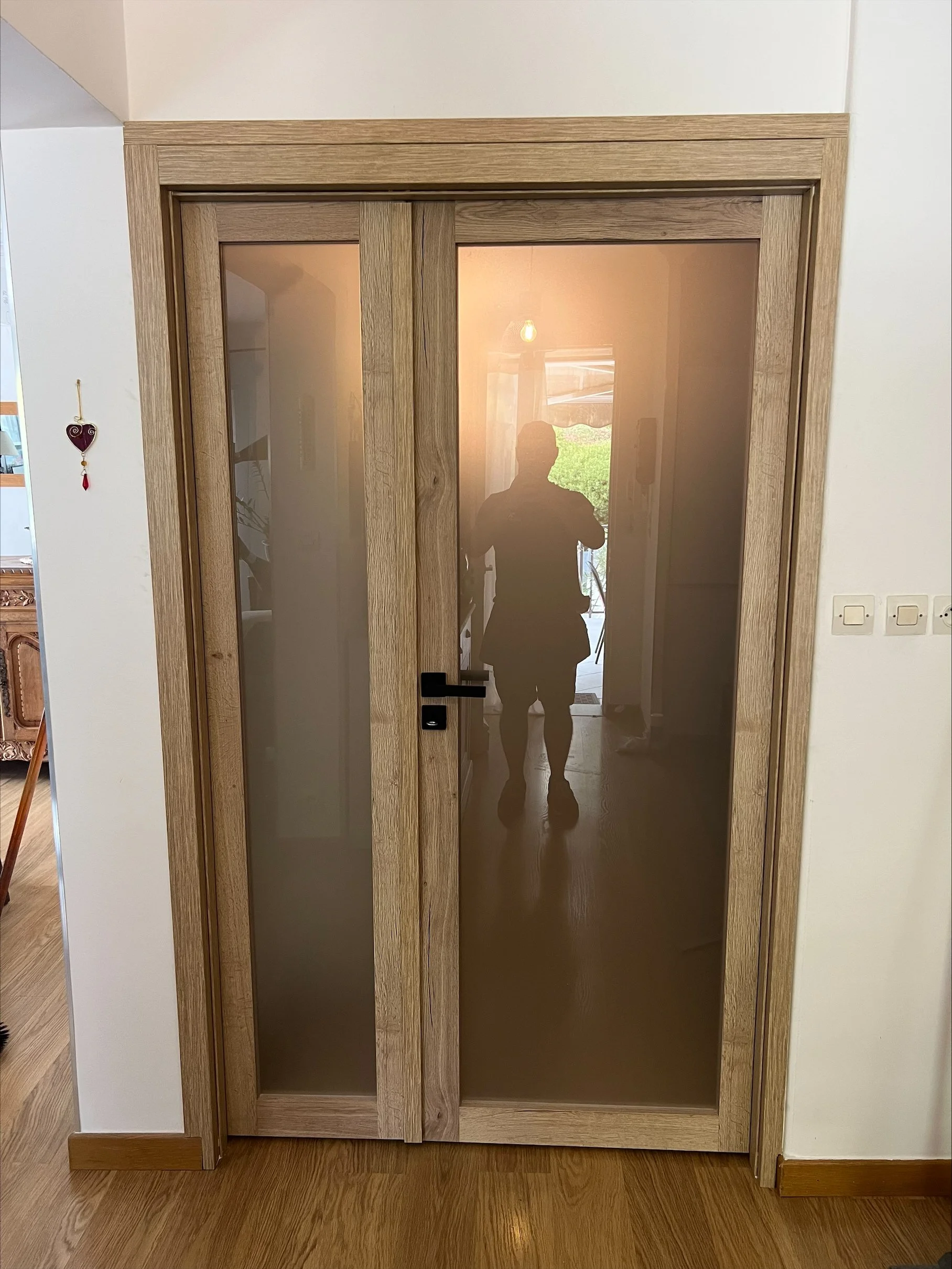 Porte à double battants en bois avec panneaux en verre dépoli opaque, dans une maison