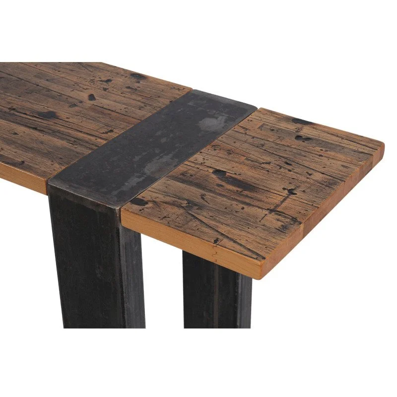Close-up of a rustic wooden table with a metal strip across the corner and black legs.