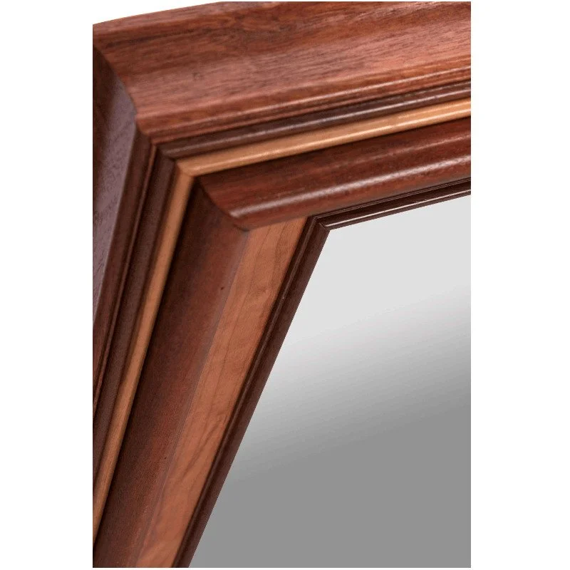 Close-up of a wooden mirror frame with detailed molding and mirror reflection.