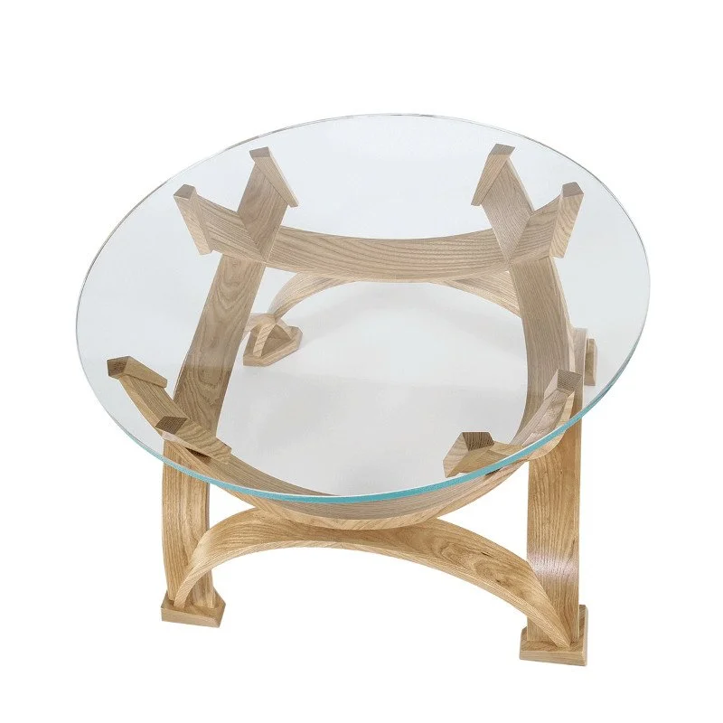 Modern table with a round glass top and wooden sculptural base