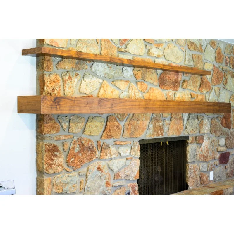 Stone fireplace with two wooden mantel shelves in a living room.