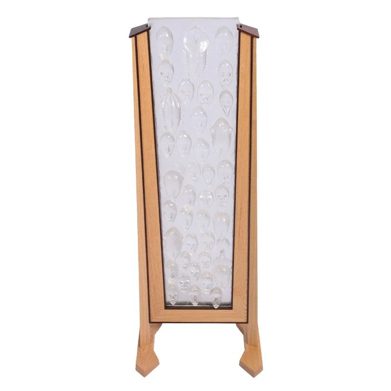 Decorative wooden frame with custom art glass insert showcasing multiple clear glass objects shaped like human heads.