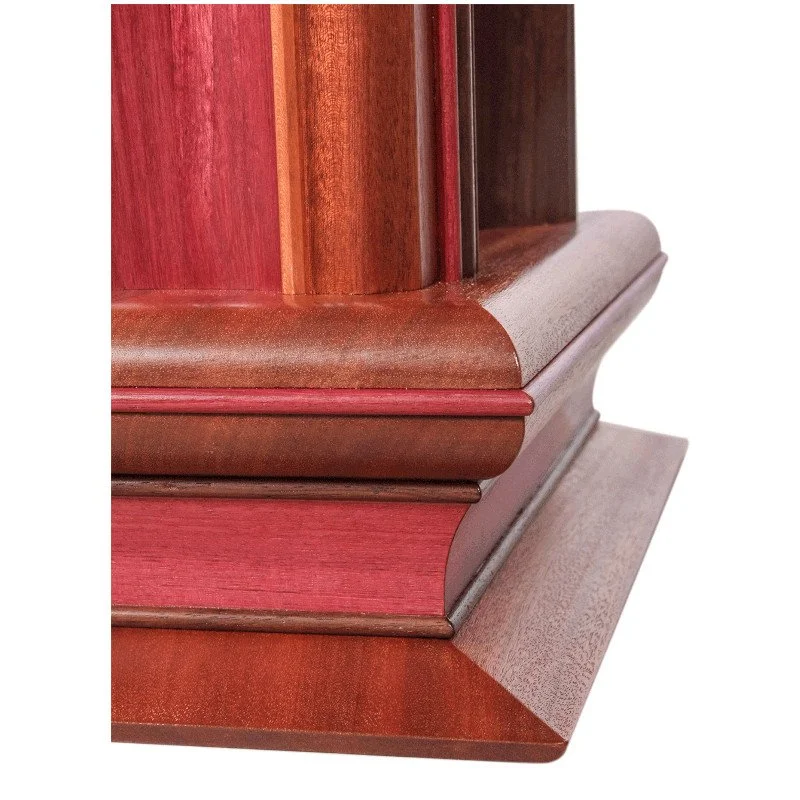 Close-up of a wooden lamp base with detailed molding and a reddish-brown finish.