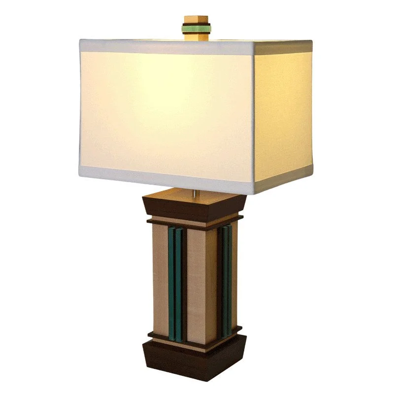 A decorative table lamp with a rectangular fabric lampshade and a wooden base featuring geometric details.
