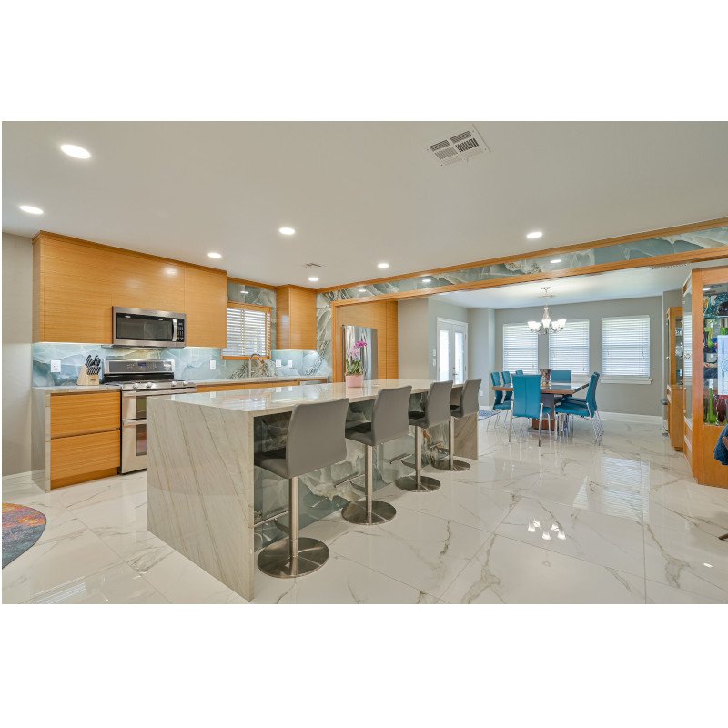 Modern kitchen with rift sawn white oak veneer, flush slab faces, and kitchen island with quartzite waterfall ends