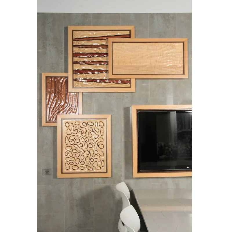 A gallery wall with various wooden art pieces and a black TV, with a white chair in the foreground.