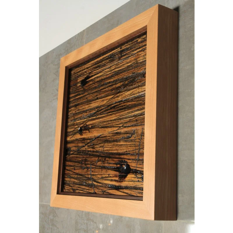 A wooden framed art display piece with rustic reclaimed wood inside of it.