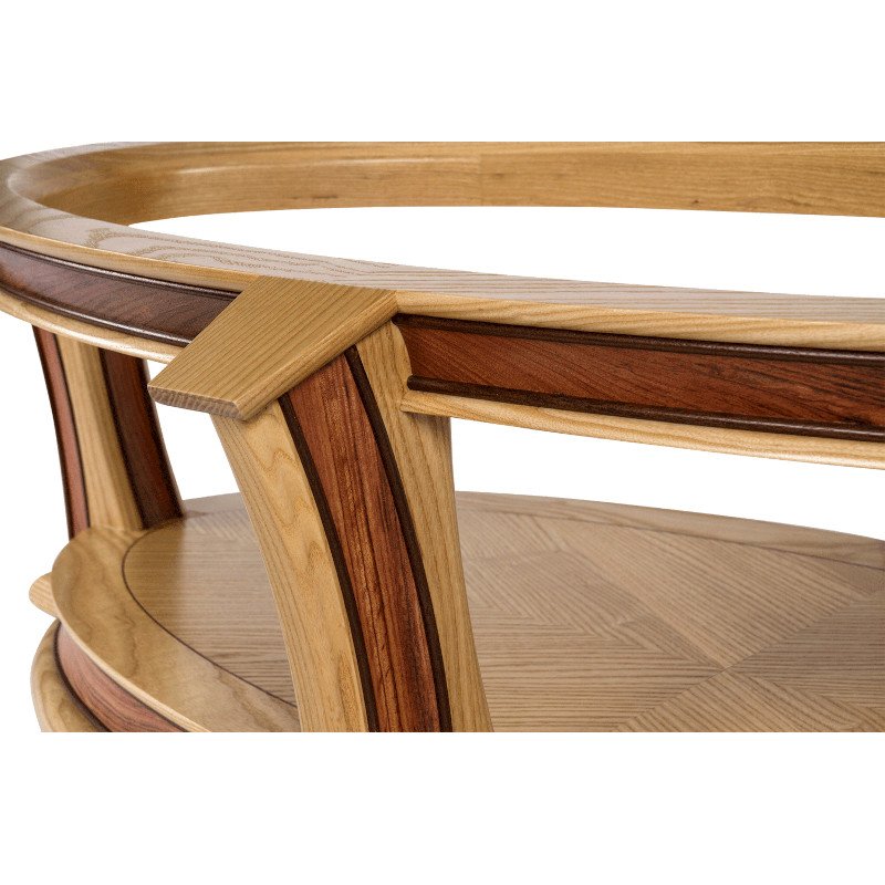Close-up of a wooden table with multiple wood tones and a curved design.