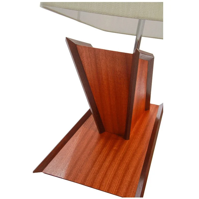 Close-up of a wooden table lamp base with a beige lampshade.