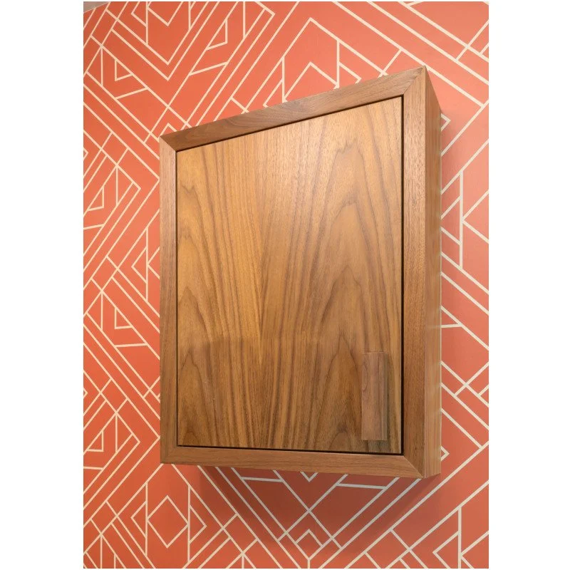 Wooden cabinet mounted on a wall with orange and white geometric patterned wallpaper.