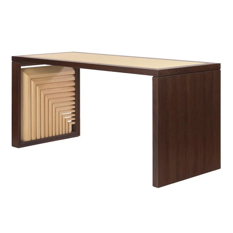 A modern wooden desk with a dark frame and a light wood surface, featuring an asymmetrical design with a slatted side panel.