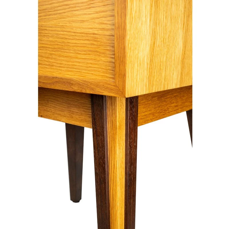 Close-up of a wooden furniture leg with a two-tone wood finish.