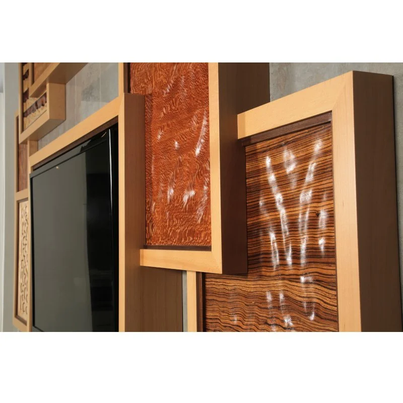 Close-up of a modern entertainment center with wooden framing and decorative wooden panels with different grain patterns and colors.