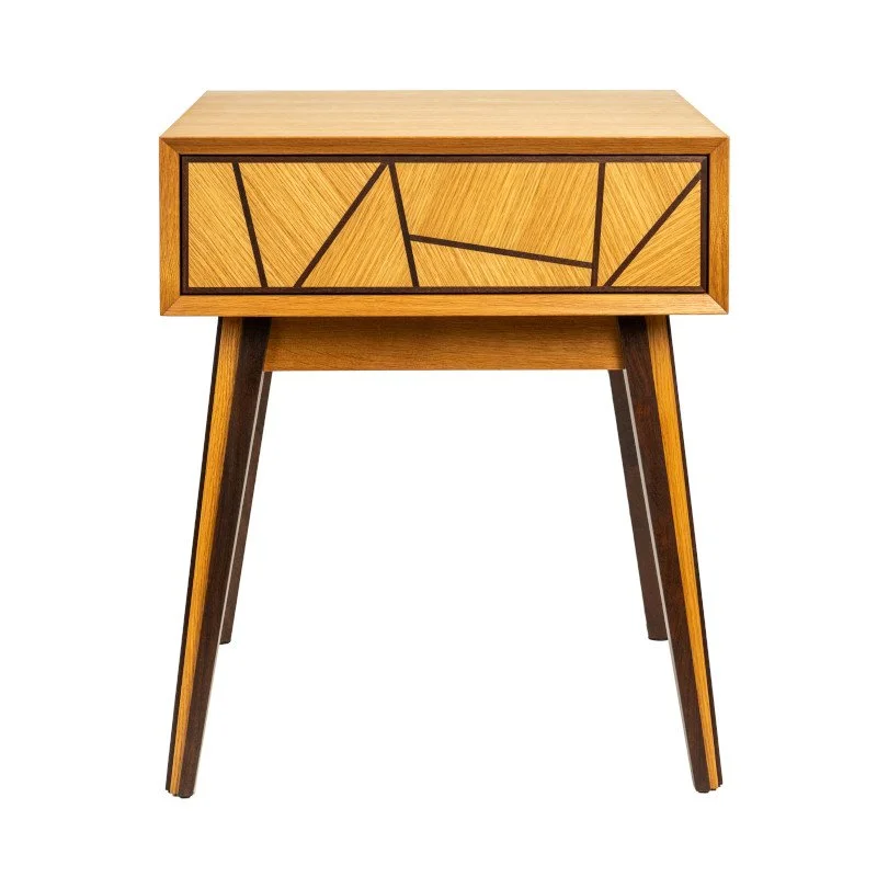 A wooden side table with geometric black line design on the front drawer, four angled legs.