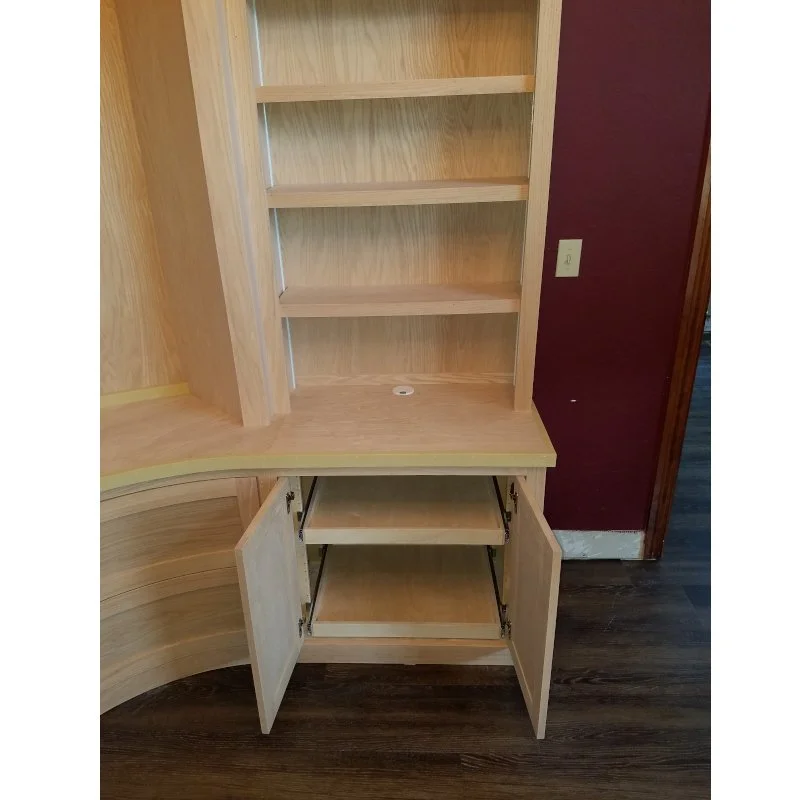 Empty wooden shelving unit with open cabinet doors and two shelves inside, located against a purple wall.