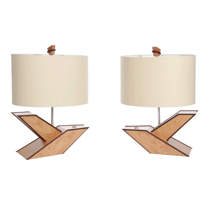 Two matching table lamps with cream-colored oval shades and wooden geometric bases.