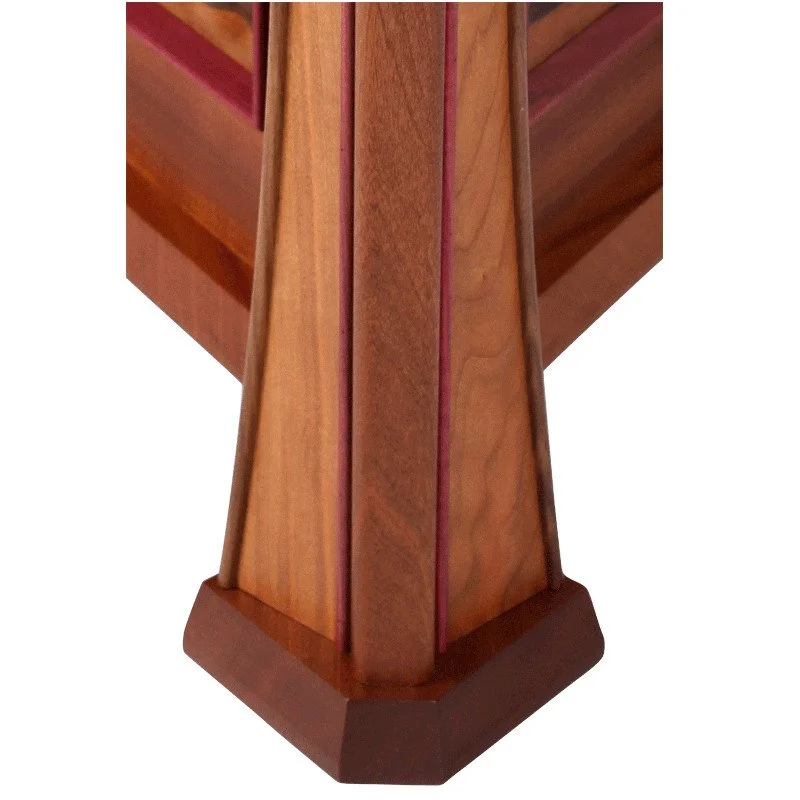 Close-up of a wooden table leg with a geometric design and natural wood finish.
