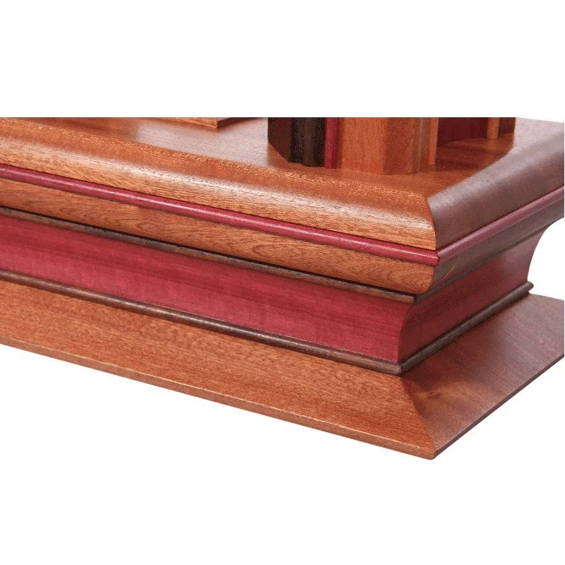 Close-up of a wooden lamp base with detailed molding and a reddish finish.