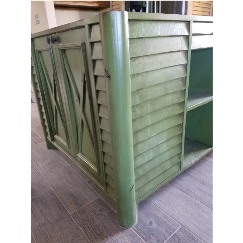 Green wooden cabinet with double doors and open shelving on the right side, situated on a tiled floor.