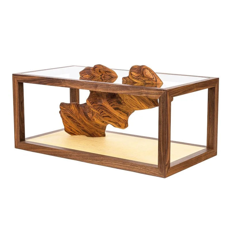 A decorative wooden sculpture inside a a wood frame coffee table, featuring a natural, abstract shape.