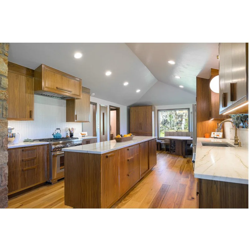 Custom mid-century modern kitchen with walnut cabinets, wood floor, an island, and quartzite countertops.