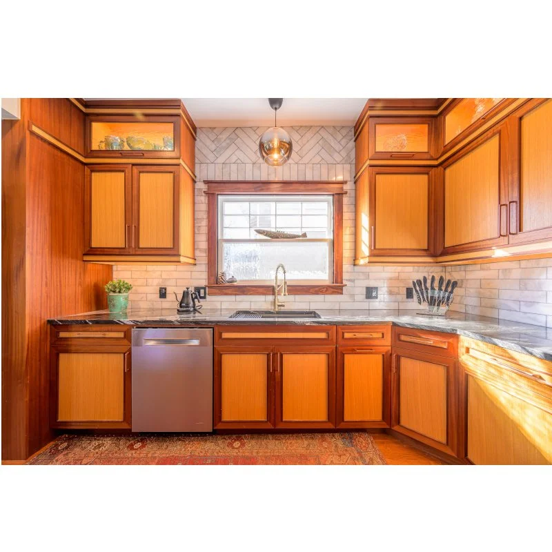 Kitchen with wooden cabinets, a window above the sink, a small dishwasher, and kitchen utensils visible.