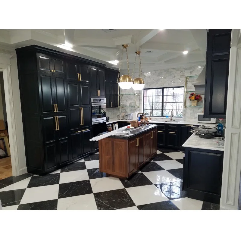 Modern kitchen with black cabinets, a wooden island, black and white checkered floor, marble backsplash, large window, and gold pendant lights.