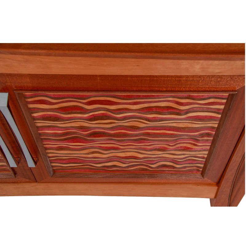 Close-up of a wooden cabinet door with a decorative carved panel.