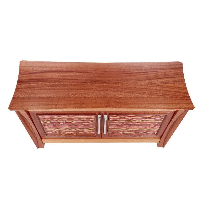 Wooden cabinet with patterned doors and curved leg details, viewed from above.