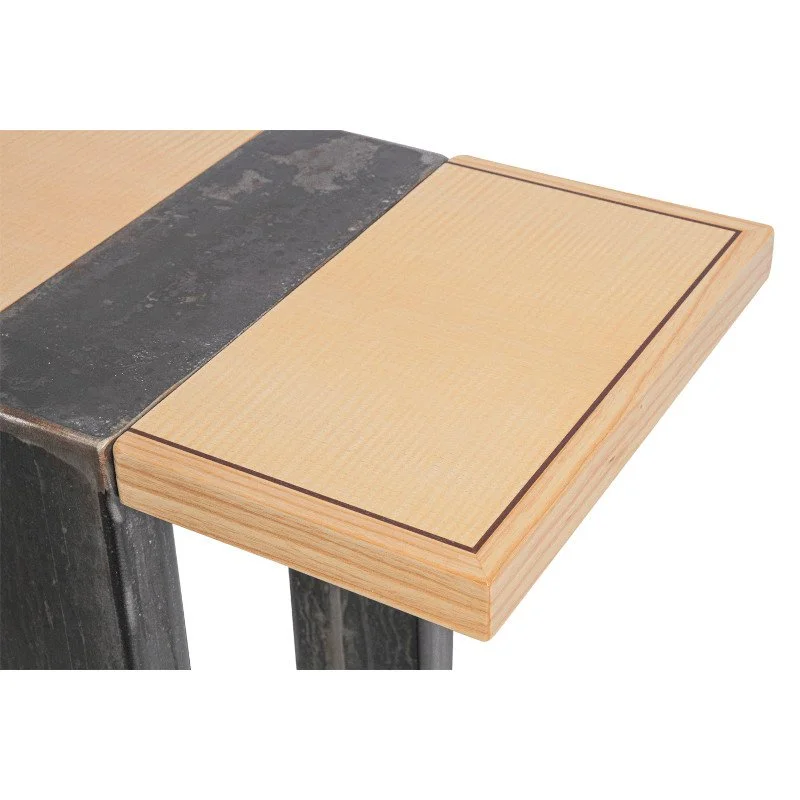 Close-up view of a wooden table with a smooth, light-colored surface and a dark border, supported by black legs.