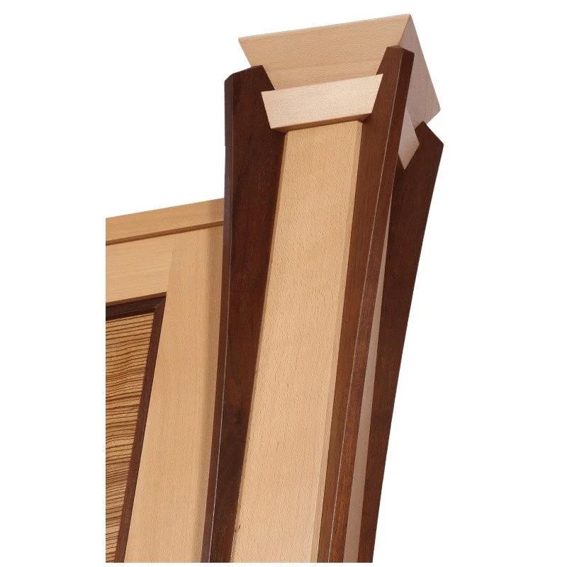 Close-up of a wooden head board featuring various shades of wood trim including light, medium, and dark brown.