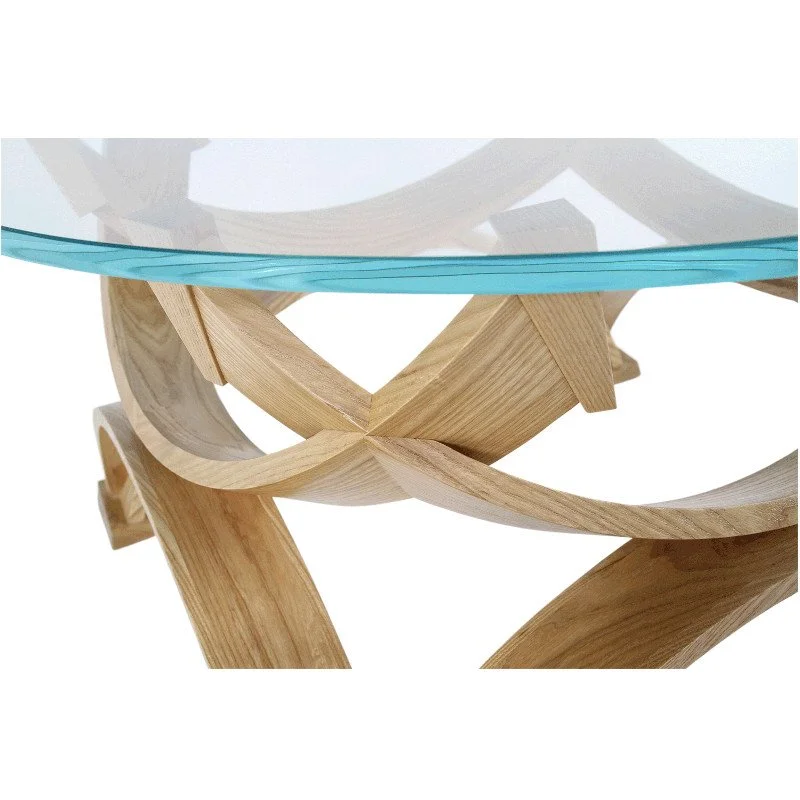 Close-up of a modern coffee table with a glass top and a sculptural wooden base.