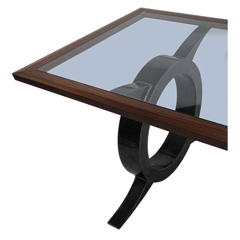 Close-up of a modern glass-top table with a black metal base and wooden frame