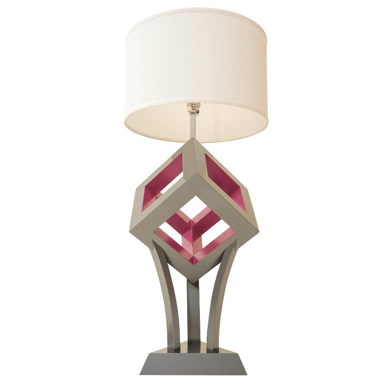 Modern table lamp with geometric design and a white drum shade.
