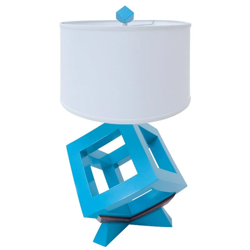 Modern table lamp with a white drum shade and a geometric turquoise base.