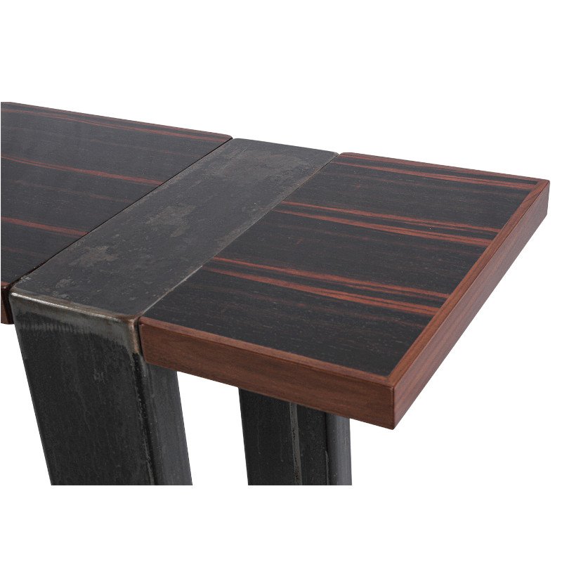 Close-up of a modern table with a black macassar ebony surface and wooden trim.